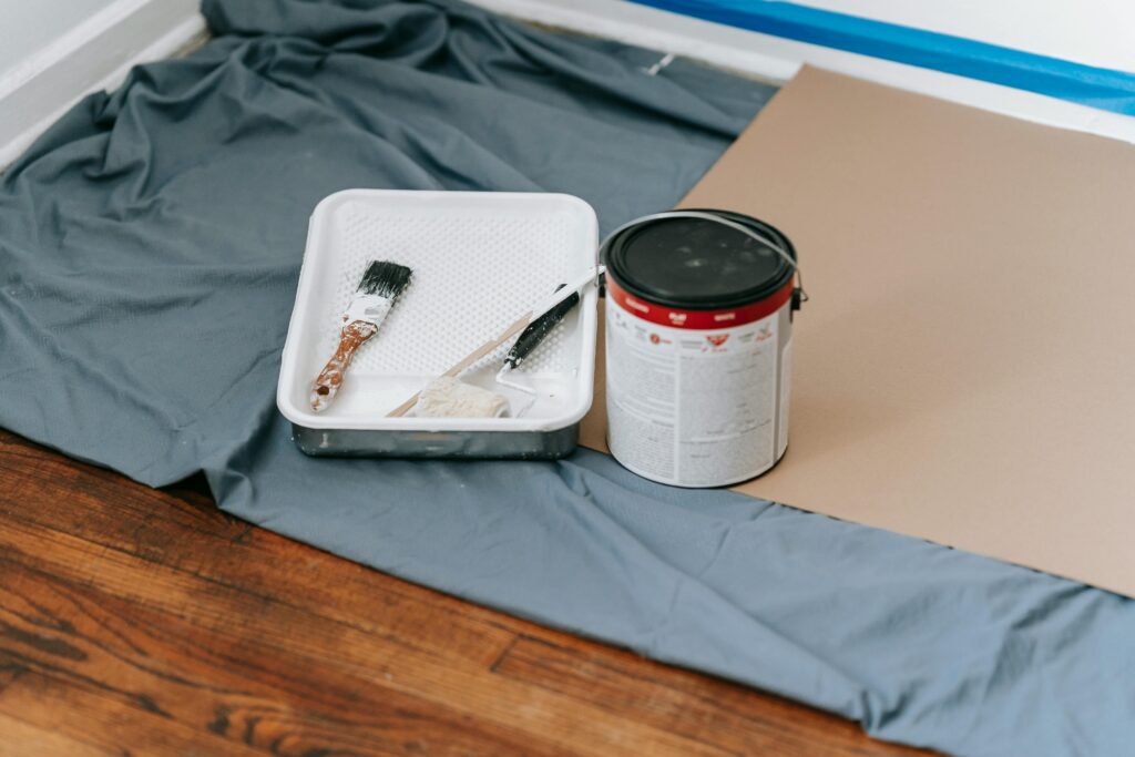 A collection of painting tools and materials prepared for a home renovation project indoors.